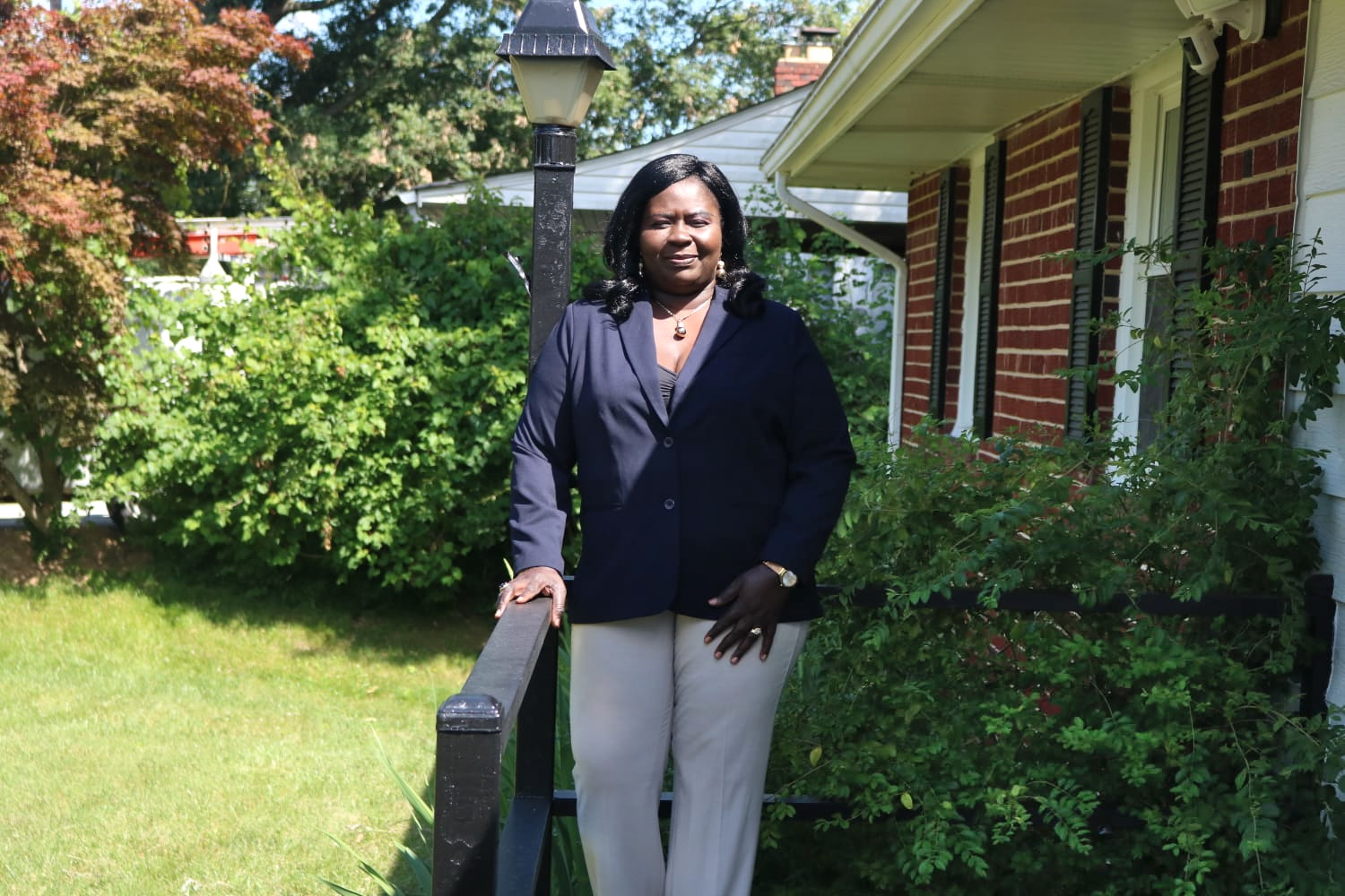 A woman standing in front of a house.